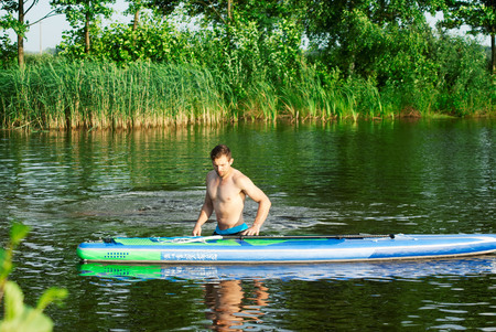 A man practicing with SAP Board, water activities, extreme hobbyの写真素材