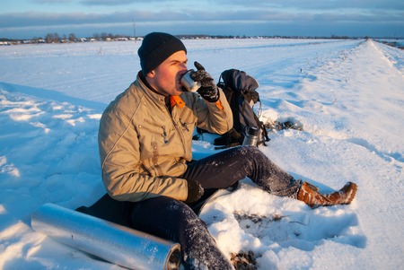 tourist over a Cup of hot tea watching the sunset, coffee on a winter day, adventure Concept outdoor activities. Winter campingの写真素材