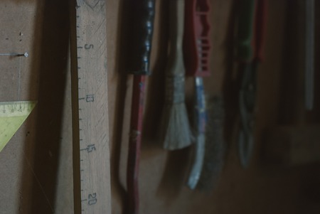 homemade wooden carpenter ruler and many more different oldtools hanging on the barn wall, old tools in the rural carpenters shed,の写真素材