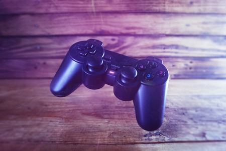 game joystick in the air on wooden background, wireless controller in pink style,の写真素材