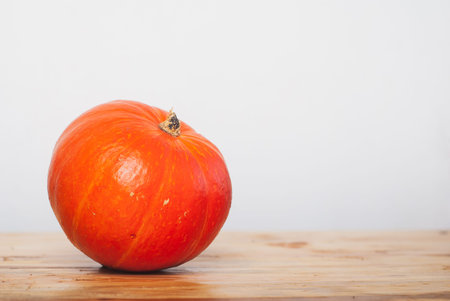 Pumpkin on a wooden table against a white wall, pumpkin minimalの写真素材