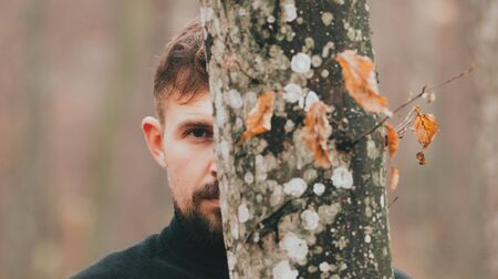 Portrait of a man close-up in the woods. The unity of man and nature. Man and treesの写真素材