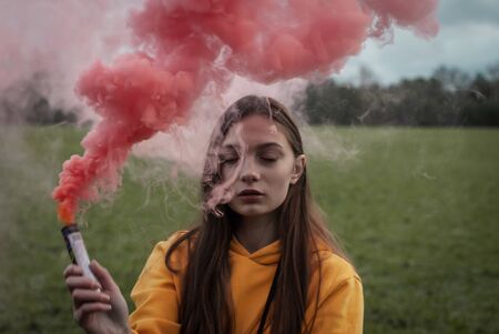 Young calm girl in pink smoke. sensual portrait,の写真素材