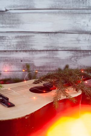 Old acoustic guitar with garland on wooden background, Christmas guitar,の写真素材