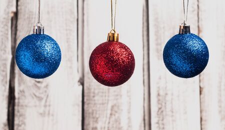Red and blue Christmas balls hanging on strings on wooden background,の写真素材