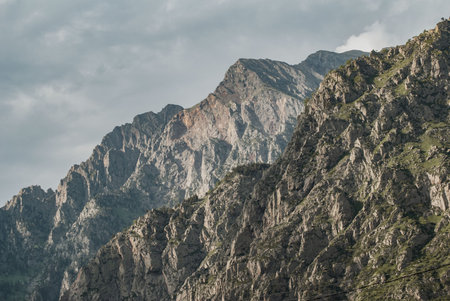 Mountain cliff close-up, clouds over the mountains