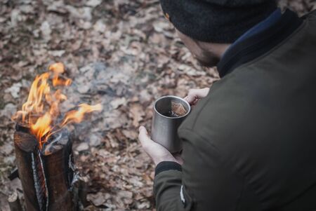 A man drinks tea from an iron mug in a campaign close-up,の写真素材