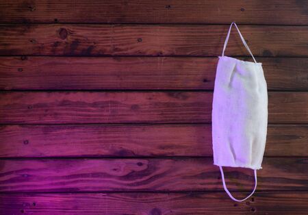a medical mask hangs on a wooden backgroundの写真素材