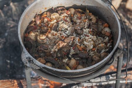 Pilaf with mushrooms in a cauldron cooked over a fire,の写真素材