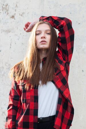 beautiful hipster girl in red shirt posing on white grunge wall background,の写真素材