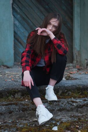 Lonely sad girl sitting in an abandoned place, cinematics portraitの写真素材