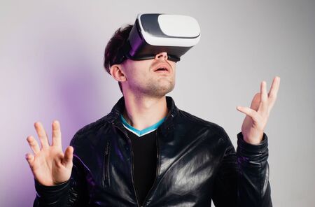 A guy in a leather jacket plunges into virtual reality using VR glasses,の写真素材