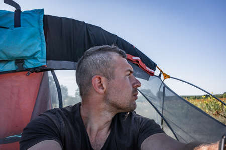 Selfie of a punk man on the background of a tent, everyday life on a hike,の写真素材