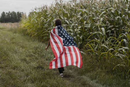 A girl runs with an American flagの写真素材