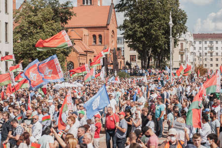 MINSK, BELARUS, AUGUST 16, 2020 rally in support of Belarusian President Alexander Lukashenko, a crowd of people with Belarusian flags against the background of the red Churchのeditorial素材