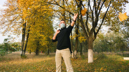 a man in a medical mask rejoices at the arrival of autumn,の写真素材