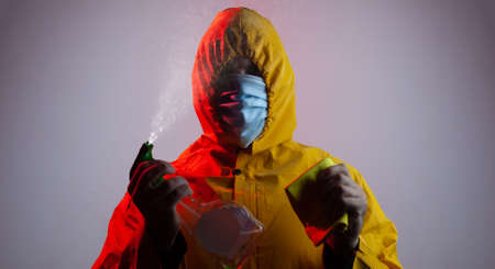 Fighting covid, a man in a suit disinfects an infected area,の写真素材