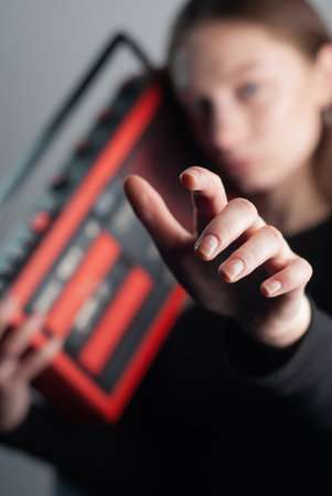A young model holds an old cassette recorder in her hands