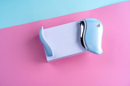guasha device ultrasonic massage pink on a blue background is a bright color for a cosmetologistの写真素材