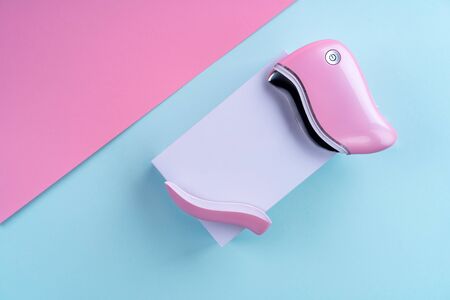 guasha device ultrasonic massage pink on a blue background is a bright color for a cosmetologistの写真素材