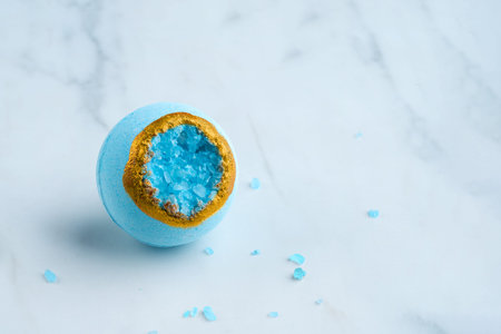 Bath bomb with sea salt crystals on a white background