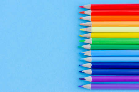Colored pencils arranged according to the colors of the rainbow on a blue background. Creativity conceptの写真素材