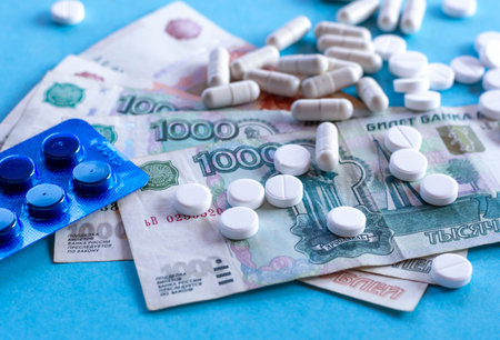 Pills (drugs) and Russian money on a blue background. The concept of health insurance, treatment...
