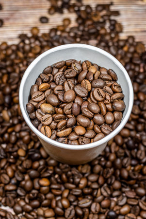 Paper cup of coffee on the background of coffee beans top view. Paper coffee cup with coffee beansの写真素材