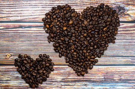 Hearts from coffee beans on a wooden table. The concept of favorite drinks, love for coffeeの写真素材