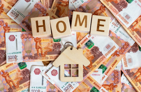 Wooden cubes with the inscription: "Home" and money with a face value of 5000 rubles. The concept of earnings, investment planning, family business, income.の写真素材