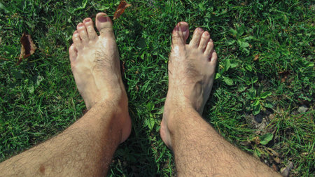 Top view, feet on green grass for background.with copy space. male legs on the green grass. a man...