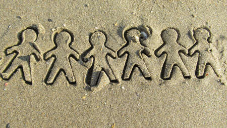 Human shapes carved on to the sea sand in a public beachの写真素材