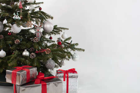 Christmas tree with three presents under it. Silver-white-red colored decorationの写真素材