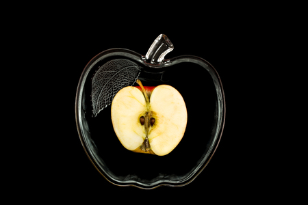 apple in a glassware over black backgroundの写真素材