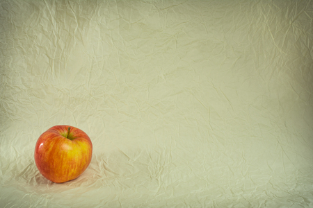 Apple in the lower left corner on crumpled paperの写真素材