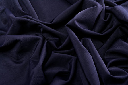 smooth dark blue satin silk fabric. folds, curl. Satin background.