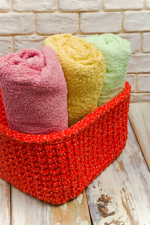Handmade knitted basket and towels on white worn boards.の写真素材