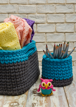 Handmade knitted basket and towels on white worn boards.の写真素材