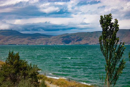 Dramatic clouds over Lake Sevan on a windy day, with mountains in the background, in summer