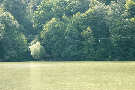 Young woman on a zipline over a calm lakeの写真素材