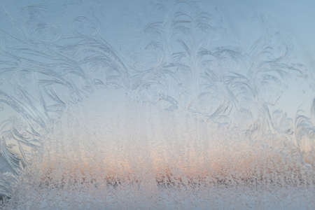 Frost texture from the ice crystals on the glass of the window, strong cold concept, horizontal image, copy space for your design or text. Snow patterns on the glassの写真素材