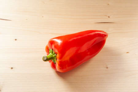 Red bell pepper on a wooden background, top view. Fresh red pepper is organic vegetable, close-up. Vitamin red product, minimum calorie contentの写真素材
