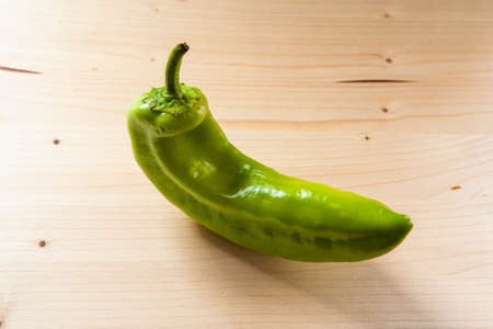 Pretty green pepper on wooden table in the kitchen, close-up. Fresh sweet green pepper on a wooden background, top viewの写真素材