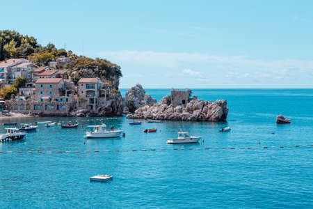 A picturesque sea bay among the mountains and rocks on the Adriatic sea coast. Mediterranean seascape with houses tiled roofs and boats on bayの写真素材