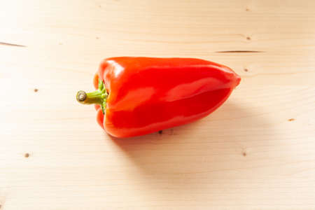 Red bell pepper on a wooden board, close-up. Fresh red pepper is organic vegetable. Vitamin red product, minimum calorie content. High quality photoの写真素材