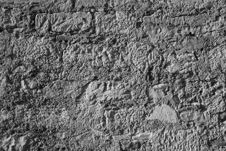 Brown stone wall, close up. Natural design with pattern of rectangular blocks and lines. Ancient masonry facade. Stone wall background for poster, calendar, post, wallpaper, card, banner, coverの写真素材