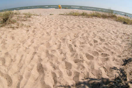 Wide angle shot of large sand beach on the sun day. Beach background for a post, screensaver, wallpaper, postcard, poster, banner, cover. High quality photographyの写真素材