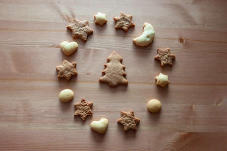 Christmas cookies - star figures, heart figures, moon figure and Christmas tree is in the center. Different figures of ginger biscuits on a wood tableの写真素材