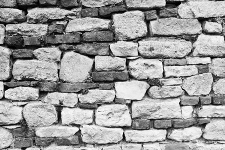 Black and white stone wall for background design. Vintage of stone backdrop. Natural stone wall textured background for a poster, calendar, screensaver, wallpaper, postcard, banner, cover, websiteの写真素材