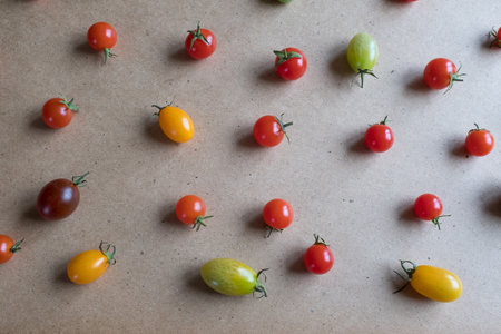 Multicolored cherry tomatoes are scattered on the table, upper view. Still life of cherry tomatoes for publication, poster, screensaver, wallpaper, postcard, banner, cover, post. Healthy dietの写真素材